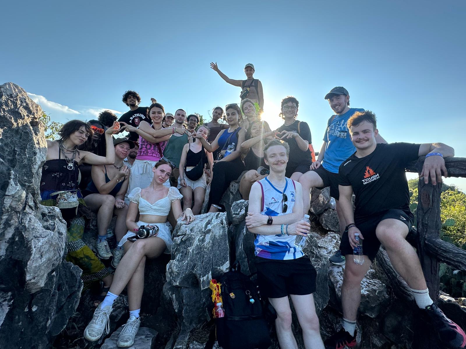 Cohort sat together on rocks at Da Nang's Marble Mountains, golden hour