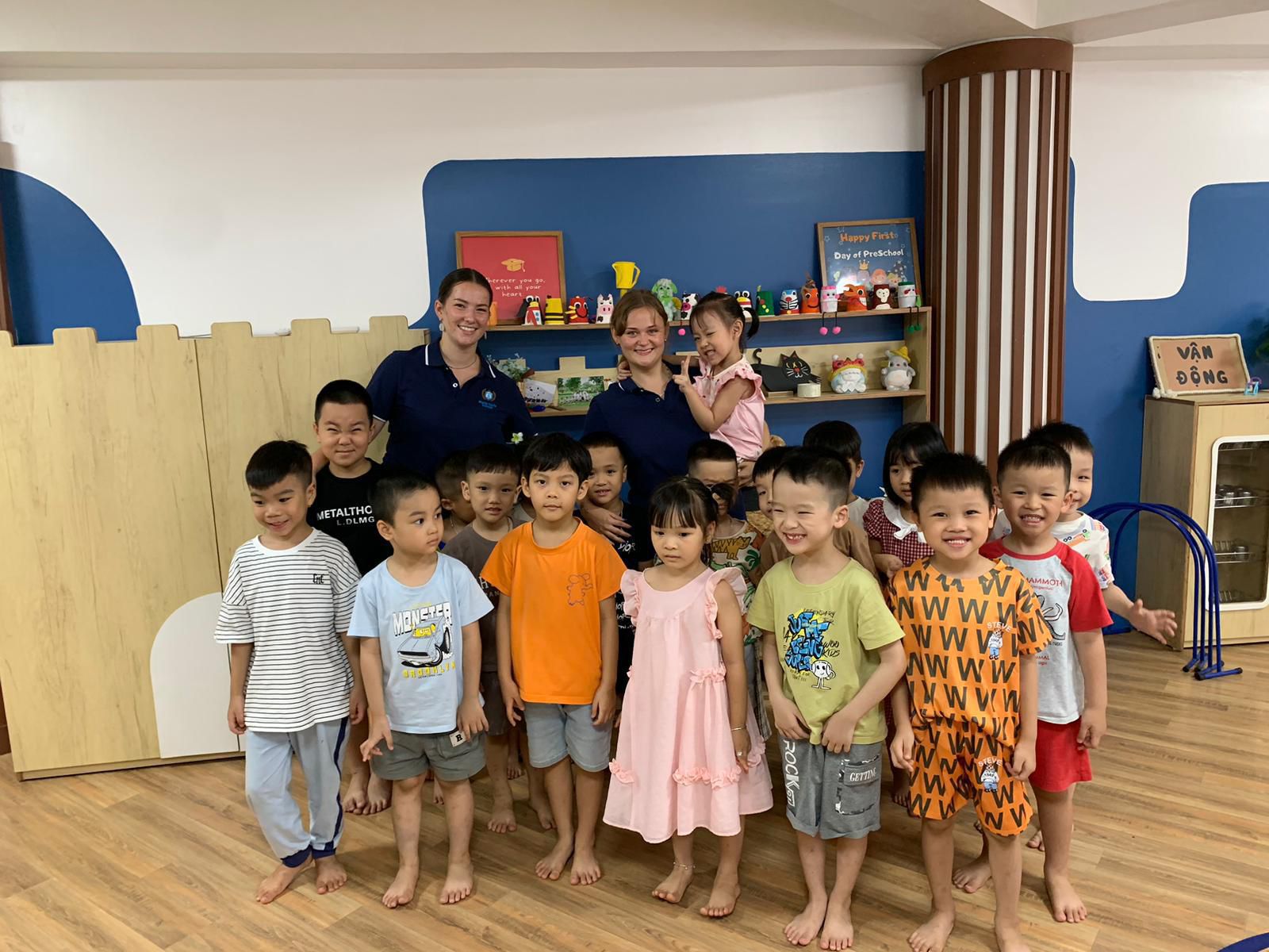 Two Gotoco'ers with their preschool class on a Happy First Day display, Vietnam